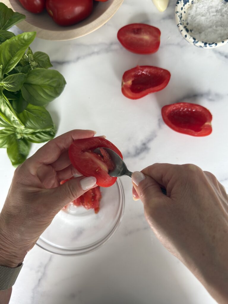 Scooping out the seeds from ripe plum tomatoes for Bruschetta al Pomodoro.