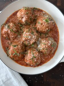 Tender baked ricotta meatballs topped with marinara and fresh basil.