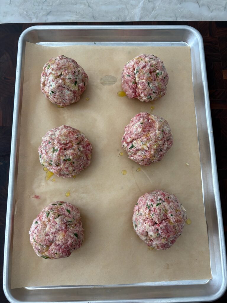Rolled ricotta meatballs ready for the oven.