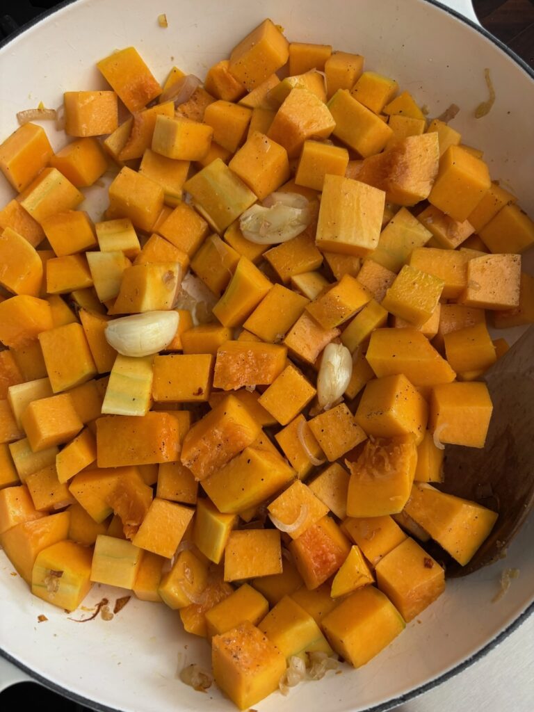 Cooking butternut squash and shallots in a skillet first step for butternut squash pasta sauce