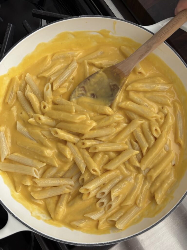 Creamy butternut squash pasta is mixed in a large white serving bowl
