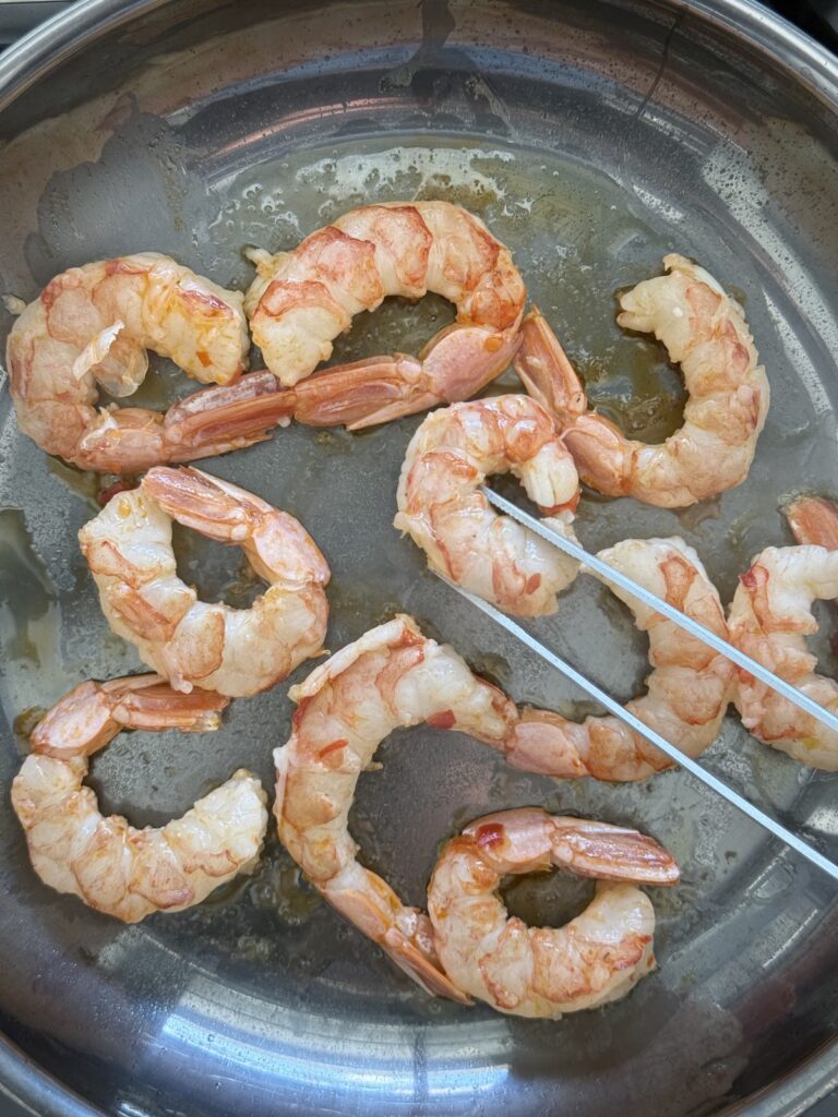 Close-up of shrimp cooking in olive oil for spicy shrimp pasta