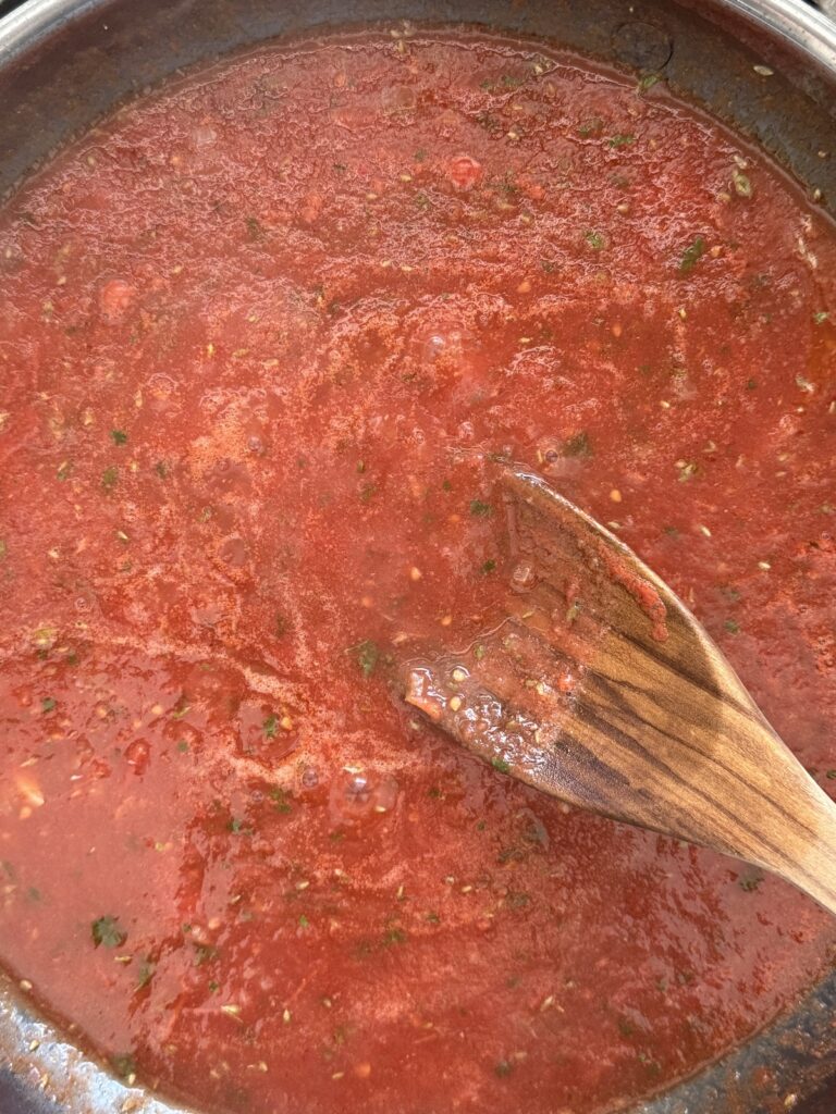 Tomato sauce simmering in a skillet for spicy shrimp pasta