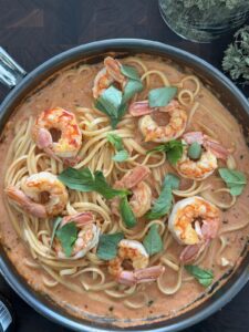 Bowl of spicy shrimp pasta topped with fresh basil ready to serve