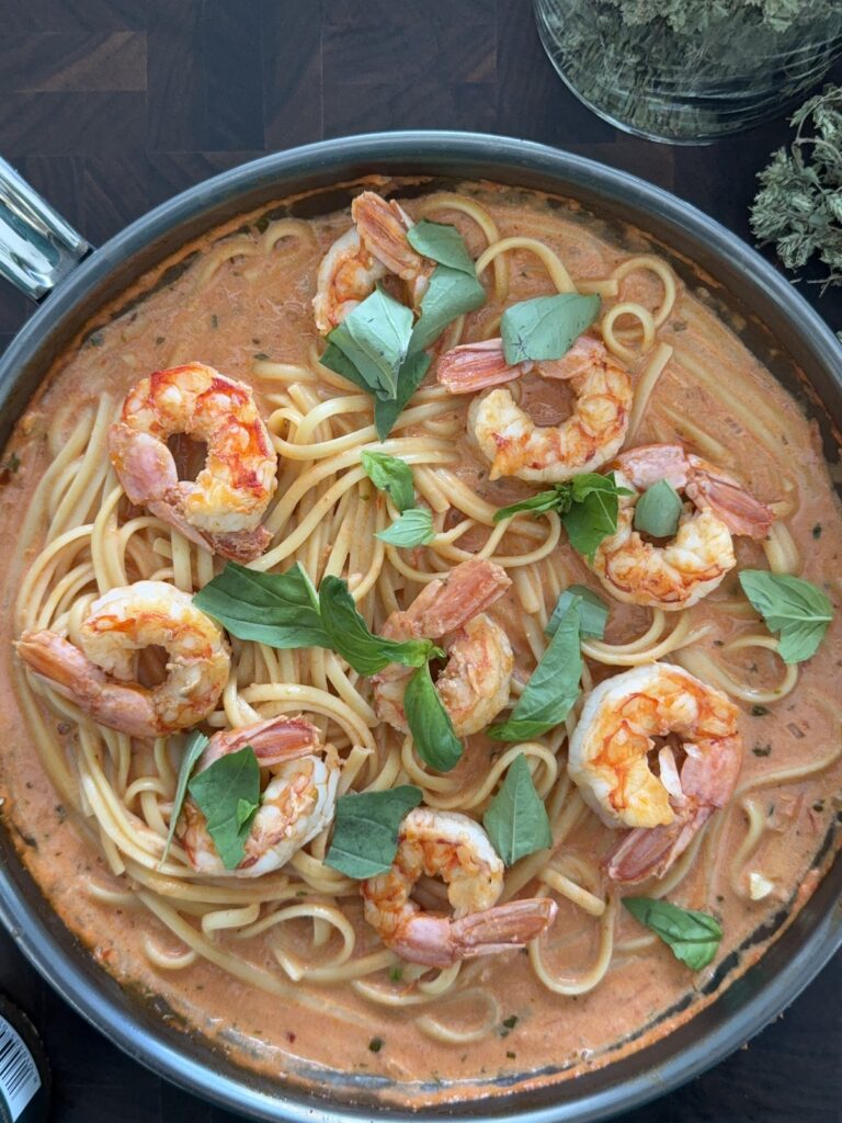 Bowl of spicy shrimp pasta topped with fresh basil ready to serve