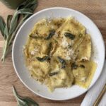 Butternut squash ravioli sprinkled with parmesan and pistachios, finished with crispy sage