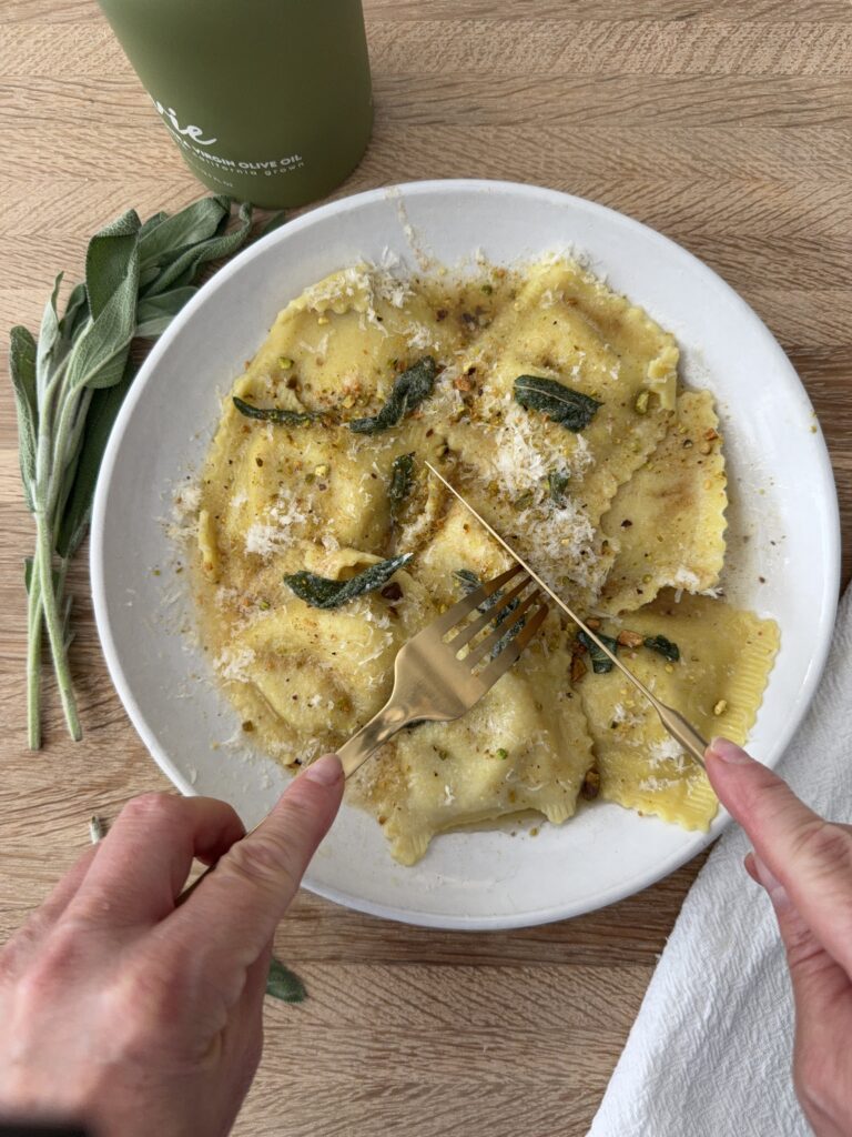 Butternut squash ravioli sprinkled with parmesan and pistachios, finished with crispy sage
