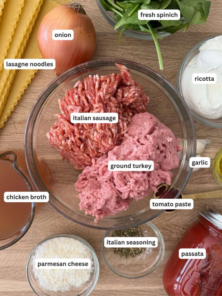 Ingredients for slow cooker lasagna soup laid out on a wood cutting board in small clear bowls
