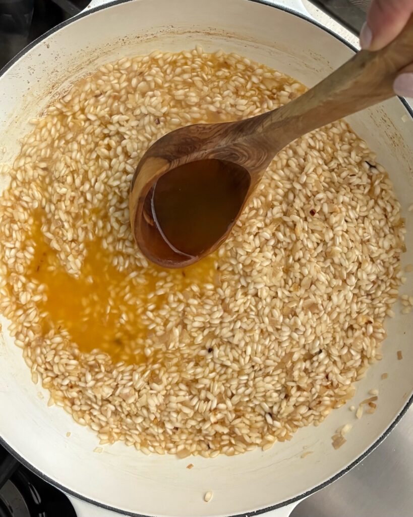 Arborio rice slowly simmers in the pan, while adding vegetable broth as the pumpkin risotto cooks.