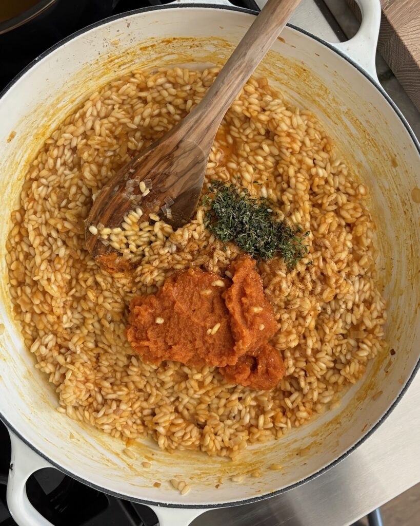 Pumpkin, maple syrup, and fresh thyme simmering with Arborio rice for creamy pumpkin risotto.