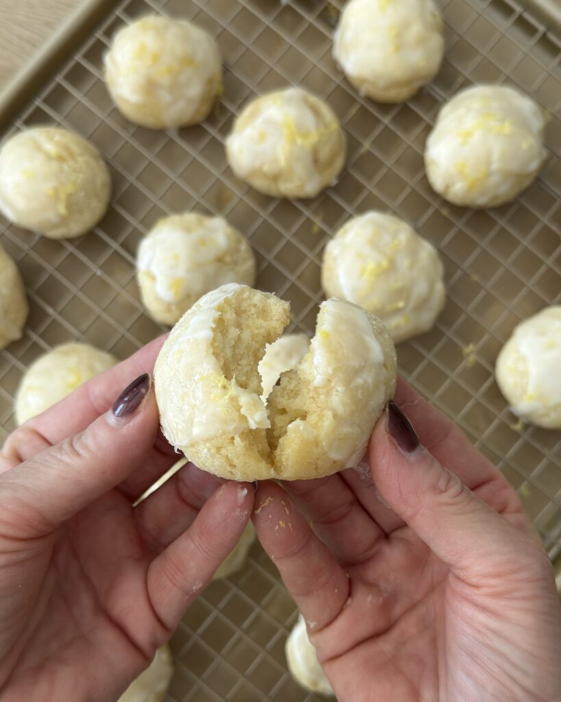 Glazed lemon ricotta cookie broken open to show the soft, tender crumb.