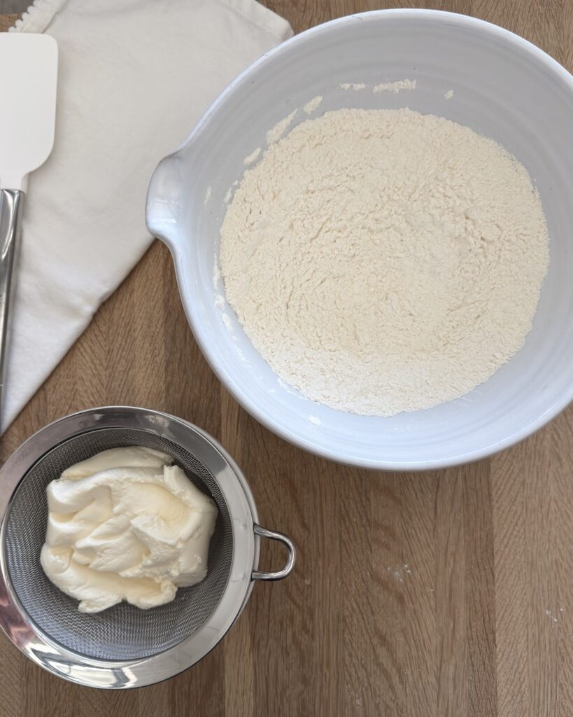 Sifted dry ingredients and drained ricotta prepared for lemon ricotta cookie dough.