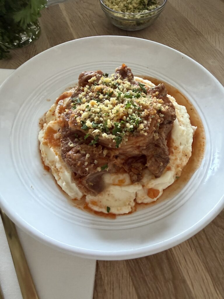 Slow cooker osso buco served over creamy mashed potatoes and topped with golden breadcrumb gremolata.