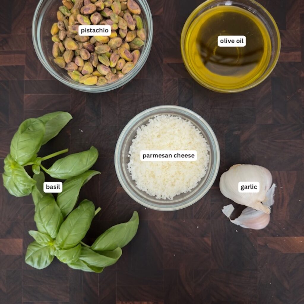 ingredients for pistachio pesto, including fresh basil, pistachios, olive oil, and Parmesan.