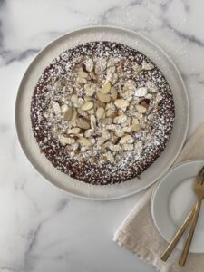 Almond ricotta cake batter spread evenly in a parchment-lined round cake pan before baking