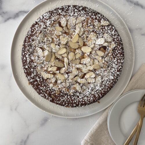 Almond ricotta cake batter spread evenly in a parchment-lined round cake pan before baking