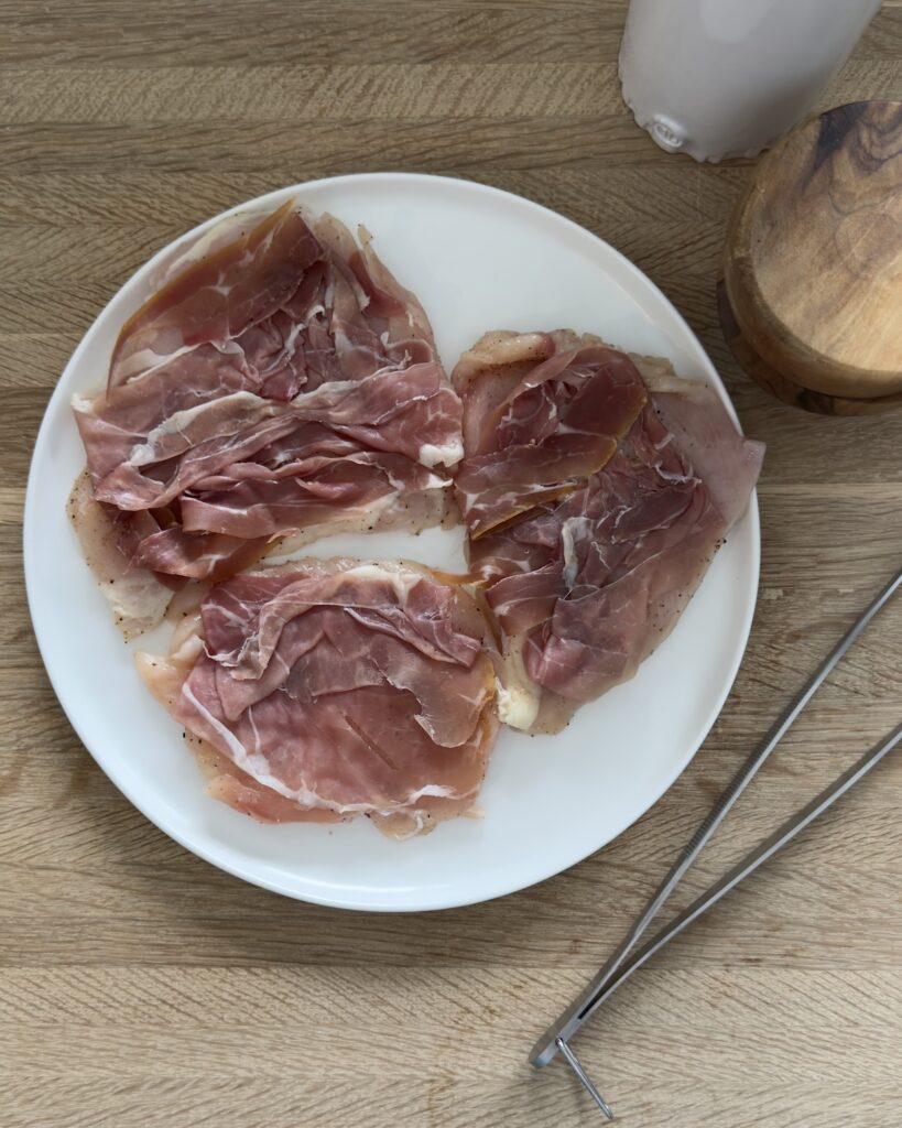 Chicken saltimbocca with prosciutto layered over thin chicken cutlets before cooking