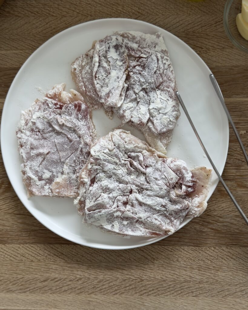 Floured chicken cutlets topped with sage for chicken saltimbocca, ready to be pan-fried
