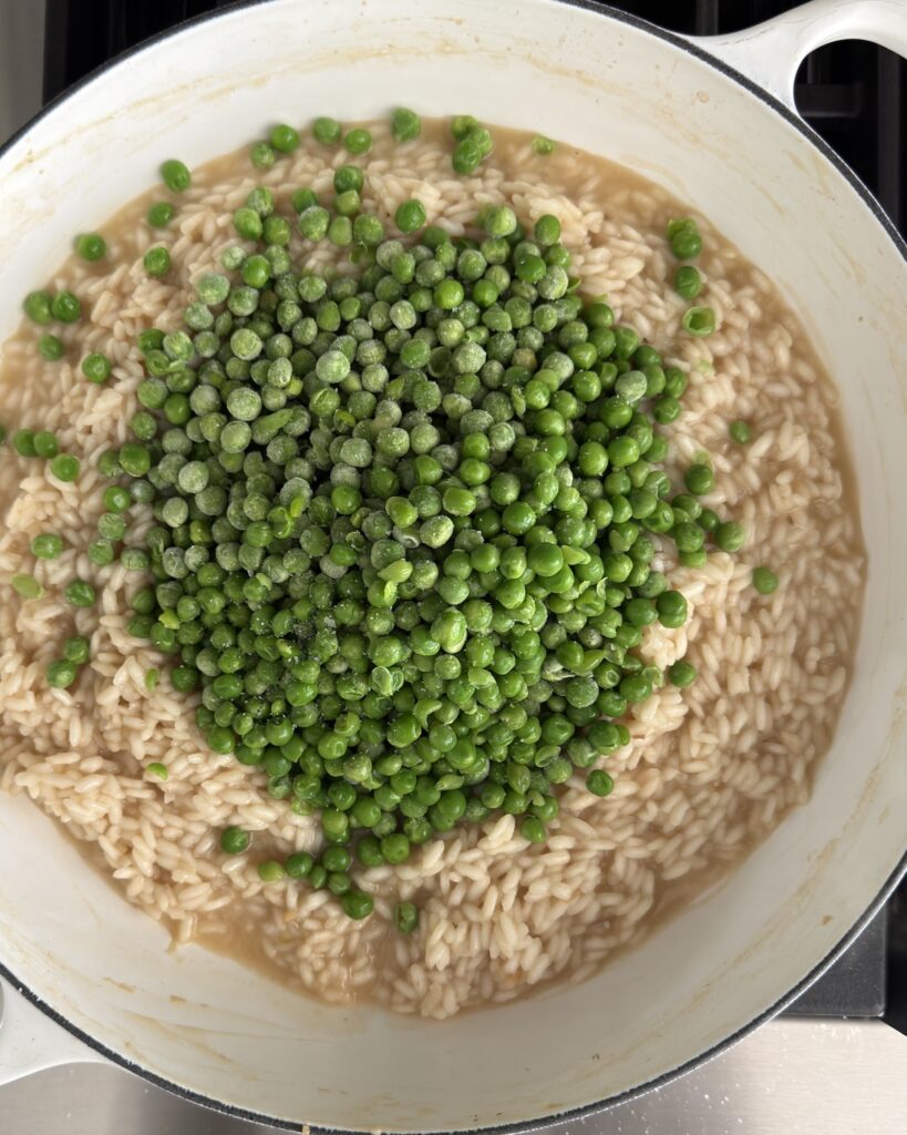 Frozen peas added to arborio rice while cooking spring pea risotto.