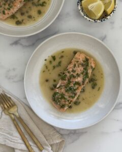 salmon piccata plated with lemon caper sauce and fresh parsley