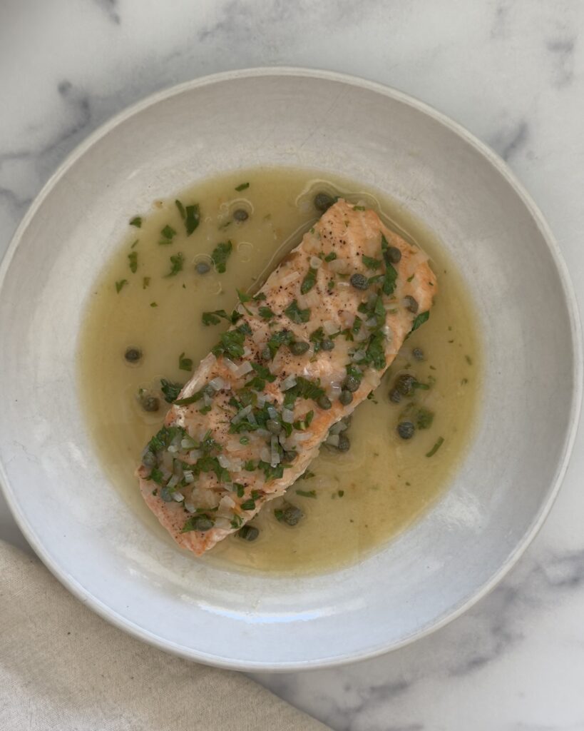 salmon piccata with lemon caper sauce plated in a bowl