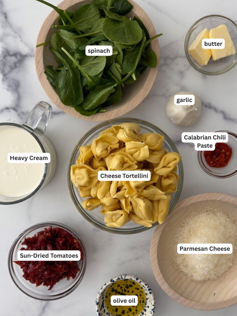 Ingredients for creamy sun-dried tomato tortellini, including spinach, cheese tortellini, Parmesan, Calabrian chili paste and heavy cream