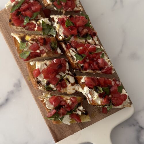 Burrata bruschetta with toasted baguette, creamy burrata, fresh tomatoes, basil, and balsamic glaze
