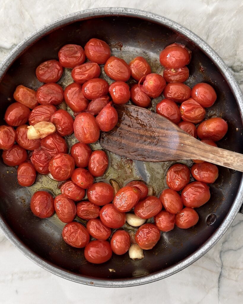 Cherry tomatoes and garlic beginning to cook in olive oil for homemade cherry tomato spaghetti sauce.