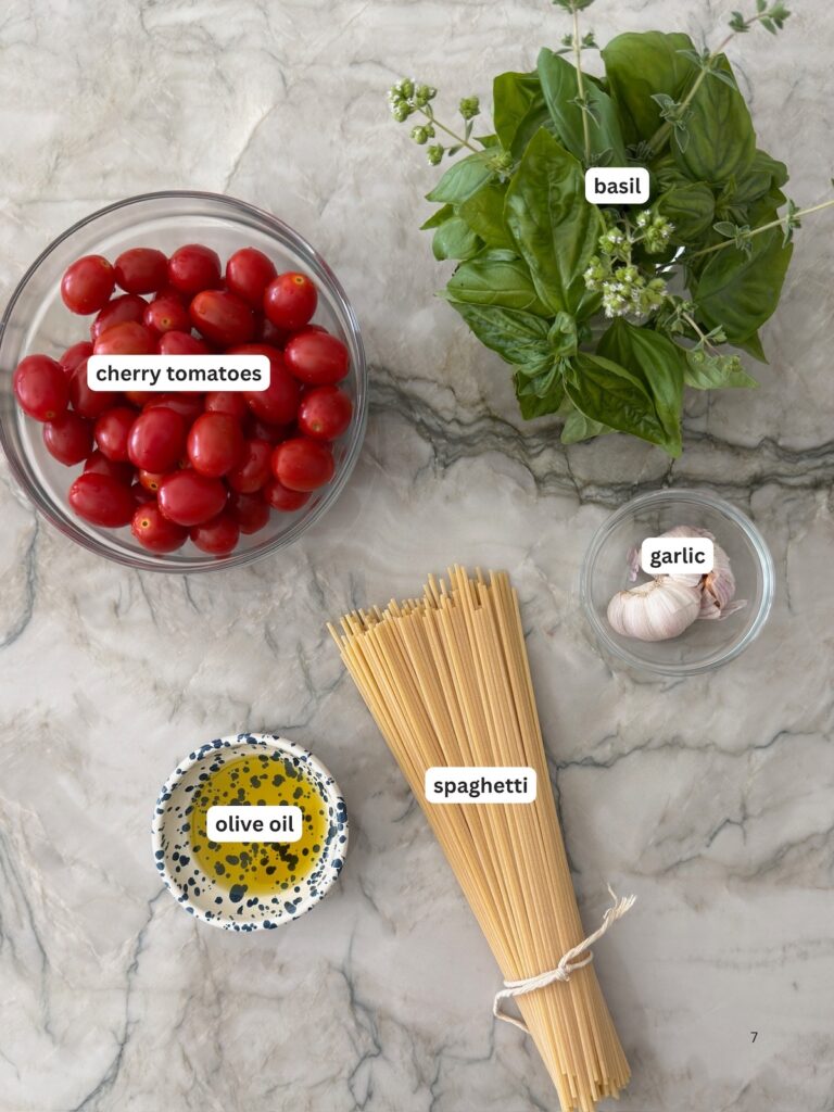 Cherry tomatoes, fresh basil, garlic, olive oil, and spaghetti ingredients for homemade cherry tomato spaghetti sauce.