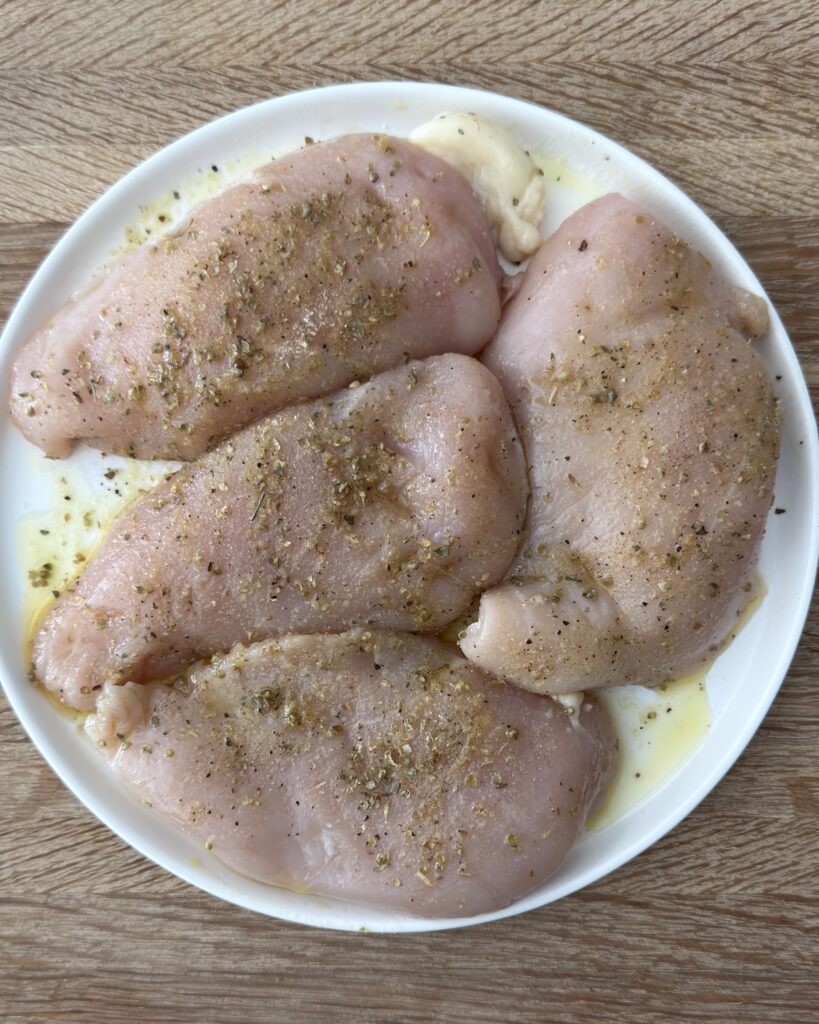 Seasoned chicken breasts with Italian herbs and olive oil for Chicken Margherita.