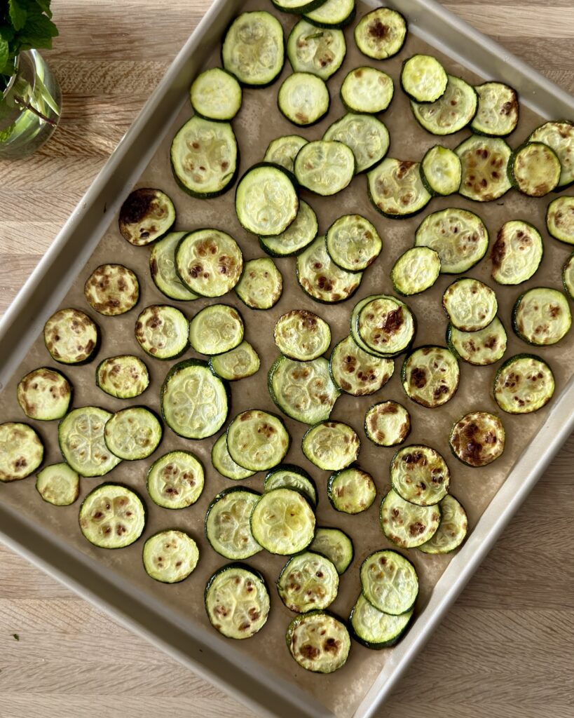 Roasted zucchini slices on a baking sheet for zucchini pasta.
