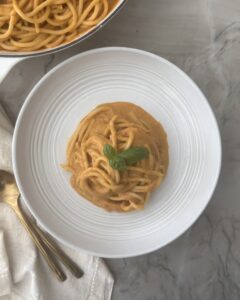 Creamy tomato pasta made with cherry tomatoes, burrata, garlic, and basil served in a white pasta bowl.