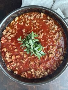 Chicken Bolognese sauce made with ground chicken and Italian sausage simmered in a rich tomato sauce with fresh oregano.
