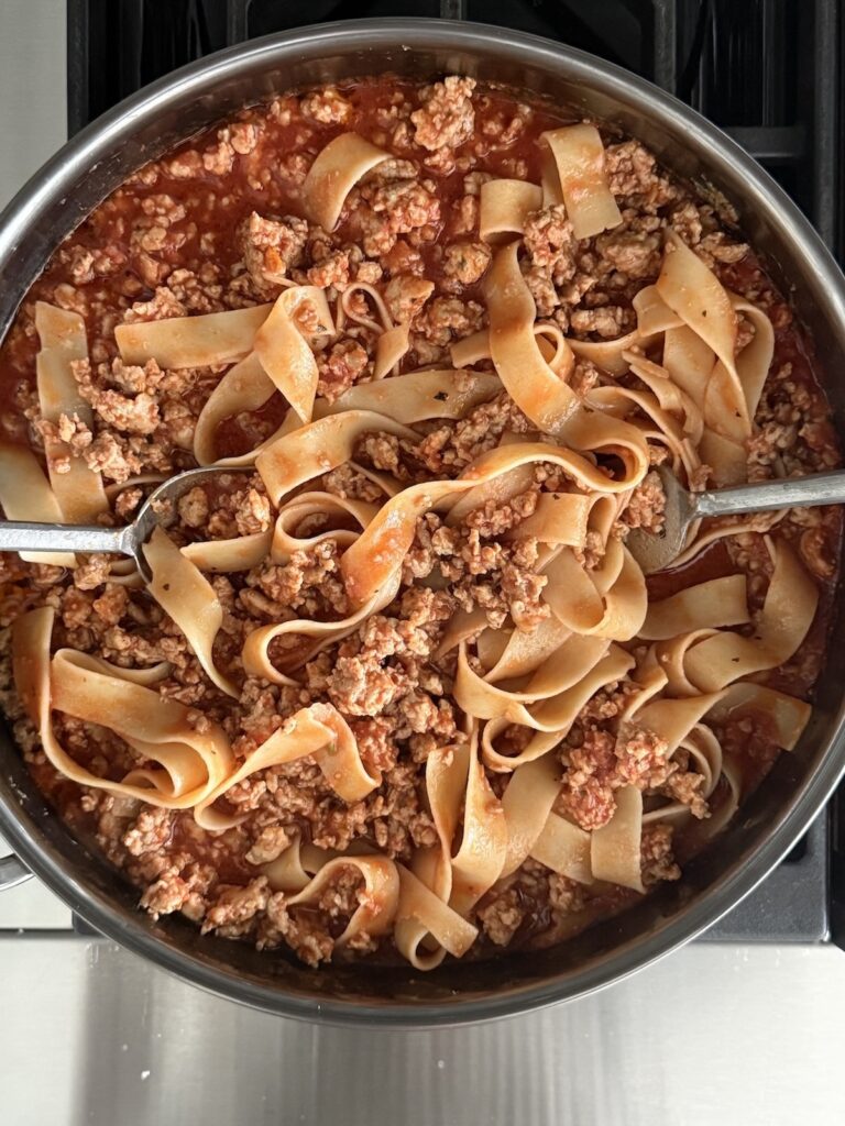 Chicken Bolognese tossed with pappardelle pasta in a rich tomato and ground chicken sauce.