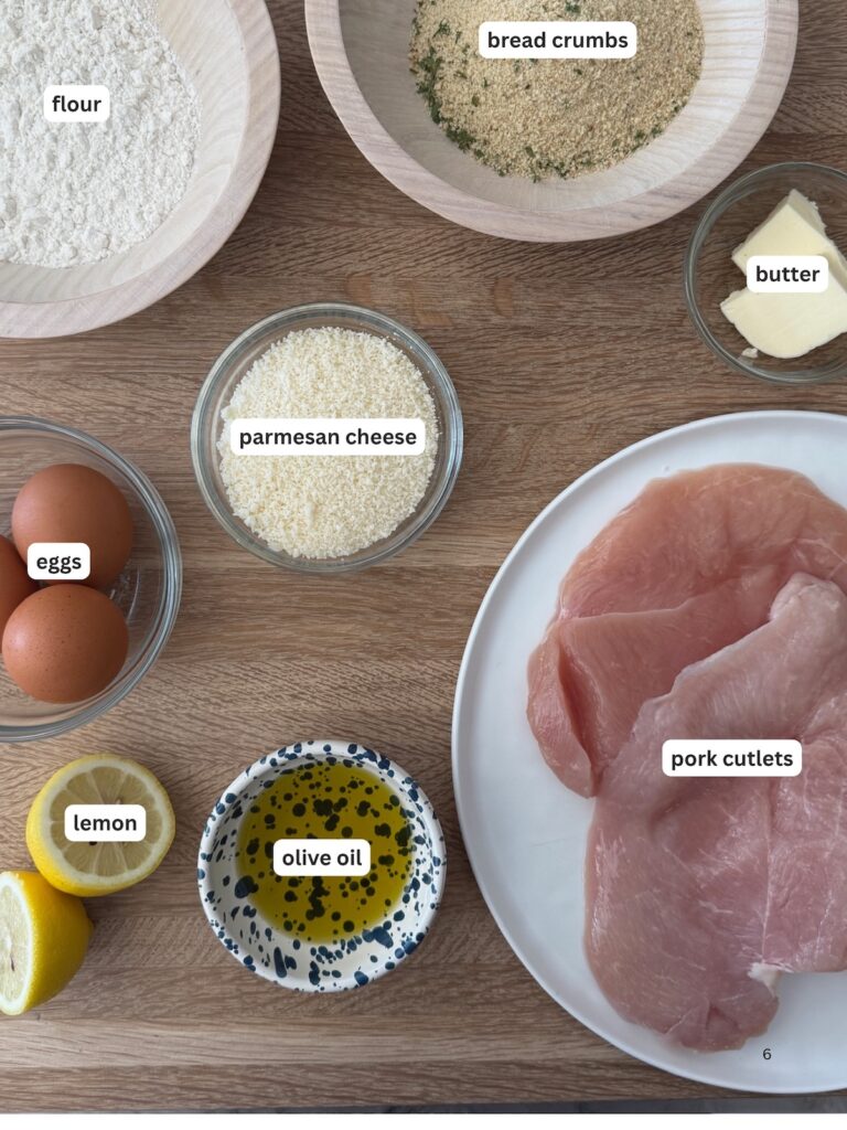 Ingredients for pork Milanese including pork cutlets, breadcrumbs, Parmesan cheese, flour, eggs, lemon, butter, and olive oil.