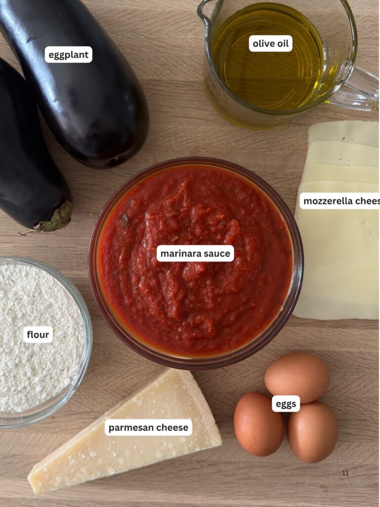 Labeled ingredients for eggplant Parmesan: eggplant, olive oil, marinara sauce, mozzarella cheese, flour, Parmesan cheese, and eggs.